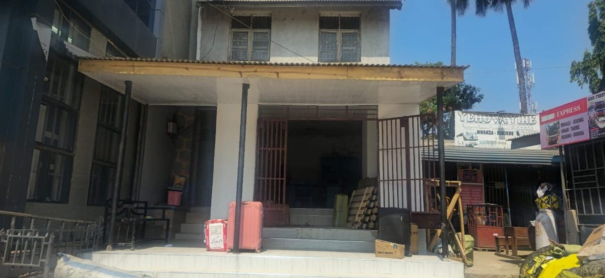Kabla: entrance ya saruji tupu, paa la muda la mbao na mabati — hakuna ceiling wala taa.