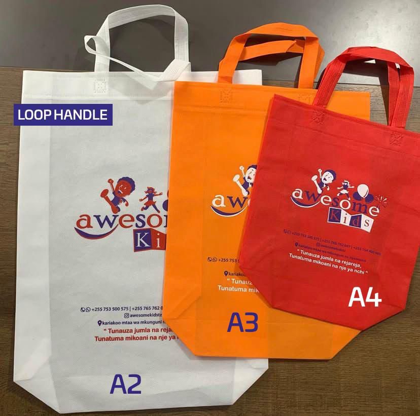 Mifuko ya non-woven ya loop handle ya rangi tatu — nyeupe, machungwa na nyekundu — ukubwa A2, A3 na A4, kazi ya DP Promotions
